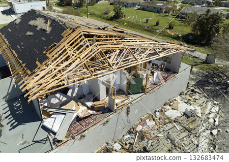 Hurricane Ian destroyed house roof and walls in Florida residential area. Natural disaster and its consequences 132683474
