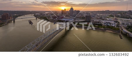 Highway traffic on bridge in Cincinnati, Ohio with brightly illuminated high skyscraper buildings in downtown district. American city with business financial district at sunset Highway traffic on bridge in Cincinnati, Ohio with brightly illuminated high skyscraper buildings in downtown district. American city with business financial district at sunset 132683492