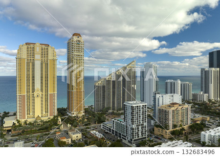 High angle view of Sunny Isles Beach city with expensive highrise hotels and condo buildings on Atlantic ocean shore. American tourism infrastructure in coastal southern Florida High angle view of Sunny Isles Beach city with expensive highrise hotels and condo buildings on Atlantic ocean shore. American tourism infrastructure in coastal southern Florida 132683496