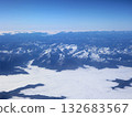 Aerial View Of Snow-Covered Mountain Range Above Clouds In Blue Sky 132683567