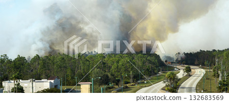 Fire department firetrucks extinguishing wildfire burning severely in Florida jungle woods. Emergency service vehicles trying to put down flames in forest Fire department firetrucks extinguishing wildfire burning severely in Florida jungle woods. Emergency service vehicles trying to put down flames in forest 132683569