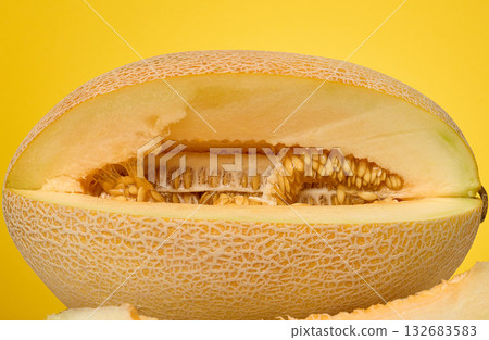 Close-up of a cut cantaloupe melon focusing on the texture of the flesh and seeds. Close-up of a cut cantaloupe melon focusing on the texture of the flesh and seeds. 132683583