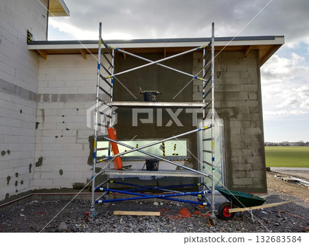 Facade of white block building under construction works. Facade of white block building under construction works. 132683584