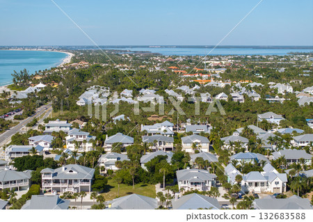 Expensive mansions between green palm trees on Gulf of Mexico shore in island small town Boca Grande on Gasparilla Island in southwest Florida, USA. Aerial view of wealthy waterfront neighborhood 132683588