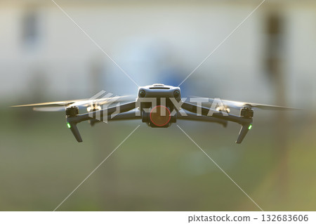 Drone aircraft with blurred fast rotating propellers and video camera flying in air Drone aircraft with blurred fast rotating propellers and video camera flying in air 132683606