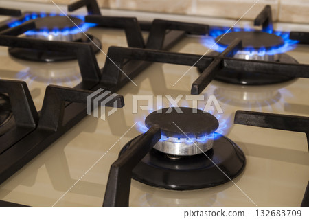 Closeup shot of blue fire from domestic kitchen stove. Gas cooker with burning flames propane gas. Closeup shot of blue fire from domestic kitchen stove. Gas cooker with burning flames propane gas. 132683709
