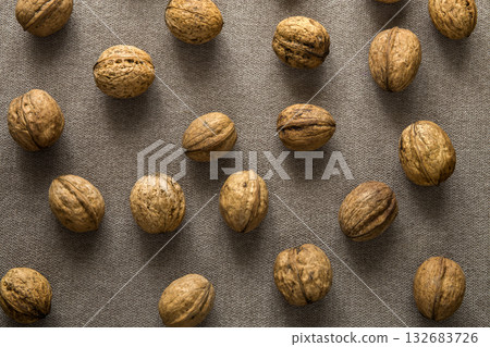 Close-up of walnuts in wooden shell isolated on light copy space background, top view. Healthy tasty organic food concept. Close-up of walnuts in wooden shell isolated on light copy space background, top view. Healthy tasty organic food concept. 132683726