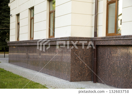 Close up view of part of a building facade with the surface of granite wall. Natural stone materials. Close up view of part of a building facade with the surface of granite wall. Natural stone materials. 132683758