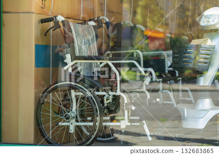 Wheelchair in Storefront. Wheelchairs displayed in shop window among packed medical equipment and mobility aids. Concept of accessibility, healthcare supply, elderly care 132683865