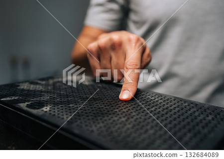 Close-up cropped shot of technician finger pointing at dust accumulation on computer case surface, emphasizing importance of regular cleaning and maintenance for optimal performance. Close-up cropped shot of technician finger pointing at dust accumulation on computer case surface, emphasizing importance of regular cleaning and maintenance for optimal performance. 132684089