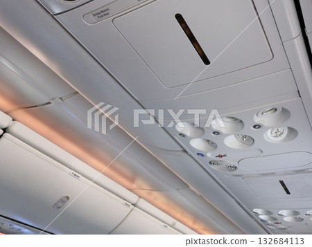 Quiet Airplane Cabin Interior Overhead Console, Reading Lights, Ventilation Controls During Flight Quiet Airplane Cabin Interior Overhead Console, Reading Lights, Ventilation Controls During Flight 132684113