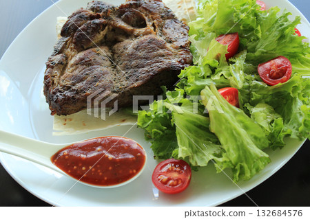 Fried meat and spicy sauce served on plate with lettuce leaves and thin bread Fried meat and spicy sauce served on plate with lettuce leaves and thin bread 132684576