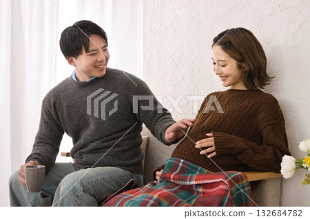 A young couple relaxing on the sofa, pregnant woman A young couple relaxing on the sofa, pregnant woman 132684782