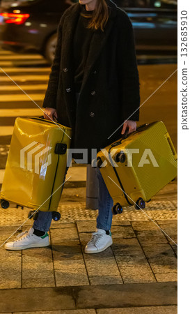 A chic traveler waits with two suitcases. A black and white concept for urban journeys, life choices, and mysterious departures. A chic traveler waits with two suitcases. A black and white concept for urban journeys, life choices, and mysterious departures. 132685910