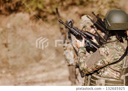 A female soldier holds a rifle during a team exercise. 132685925