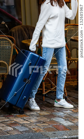 A modern traveler with a suitcase on a cobblestone street. A modern traveler with a suitcase on a cobblestone street. 132685967