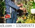 A stylish woman with a modern handbag shops for flowers. 132685973