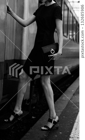 An elegant woman boards a train. An elegant woman boards a train. 132685986