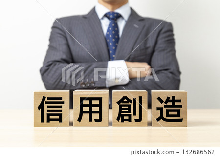 A businessman with his arms crossed and a block with the word "Credit Creation" written on it 132686562