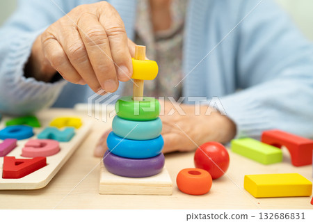 Alzheimer disease AD, Asian elderly woman patient suffering from dementia learn practical motor skills rehabilitation. Alzheimer disease AD, Asian elderly woman patient suffering from dementia learn practical motor skills rehabilitation. 132686831