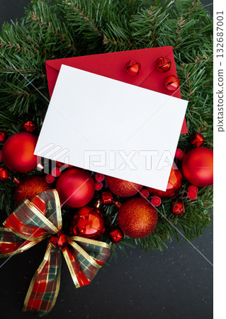 Christmas handmade wreath made of festive decorations with red envelope copy space mock up template white paper sheet. Winter holiday celebration greeting card Christmas handmade wreath made of festive decorations with red envelope copy space mock up template white paper sheet. Winter holiday celebration greeting card 132687001