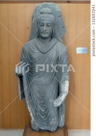 A statue of the Abhaya mudra Buddha, unfortunately missing its right arm, on display at the Taxila Museum in Pakistan, east of Gandhara 132687041