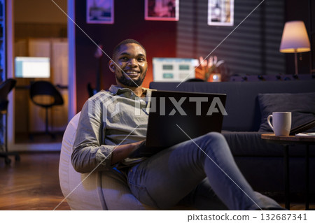 Male analyst examining monthly budget and expenses to provide strategic advice on products and services. Black young business expert analyzing revenue balance, accounting at home. 132687341