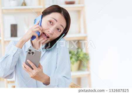 一位忙碌的女性，擁有多部智慧型手機 132687825