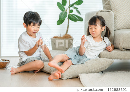 一對關係親密的兄妹在客廳的沙發上吃零食 132688891