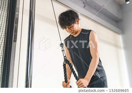 一名年輕的亞洲男子在健身房進行繩索訓練（肌肉訓練，繩索下拉） 132689685