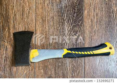 an axe with a fiberglass handle on a wooden background 132690271