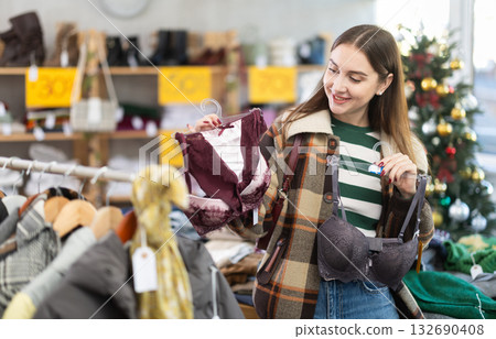Young woman choosing bra set in Christmas boutique Young woman choosing bra set in Christmas boutique 132690408