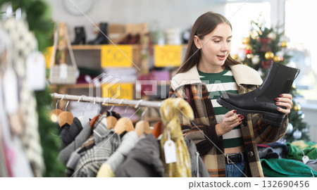 Young woman chooses ankle boots in store Young woman chooses ankle boots in store 132690456