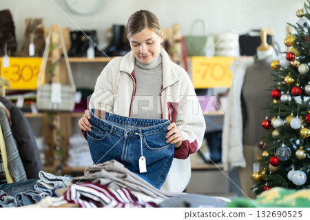 Adult woman choosing jeans in clothing store Adult woman choosing jeans in clothing store 132690525