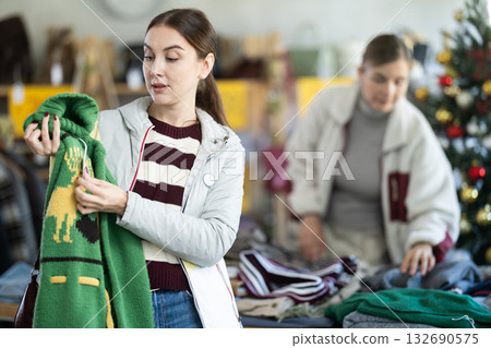 Woman choosing a reindeer sweater for Christmas and New Year Woman choosing a reindeer sweater for Christmas and New Year 132690575