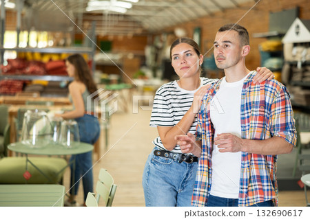 Interested couple looking for functional furniture in garden store 132690617