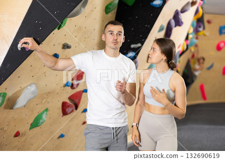 Friendly climbers chatting near bouldering wall in indoor gym 132690619