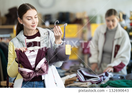 Young woman choosing bra set in Christmas boutique Young woman choosing bra set in Christmas boutique 132690643