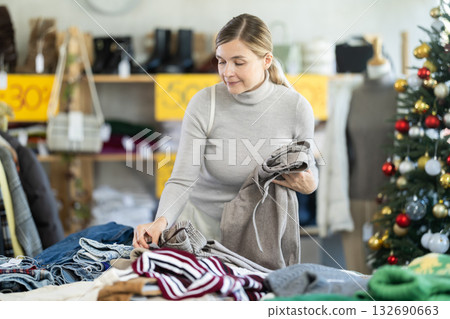 Adult woman choosing trousers in clothing store Adult woman choosing trousers in clothing store 132690663
