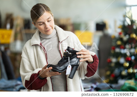 Adult woman chooses heeled ankle boots in store 132690672