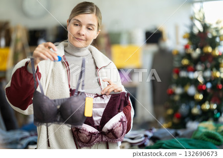 Young woman choosing bra set in Christmas boutique 132690673