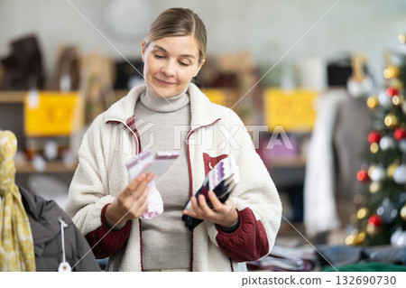Adult woman chooses socks in clothing store Adult woman chooses socks in clothing store 132690730