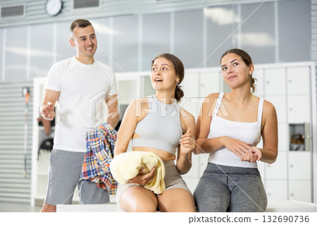 Young man intervenes in conversation between two girls in dressing room. 132690736