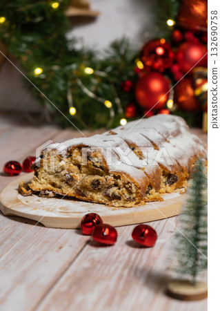 Homemade Christmas traditional cake pie with marzipan nuts and dried fruits pastry dessert stollen. Winter holidays season atmosphere. Delicious tasty composition home table setting 132690758