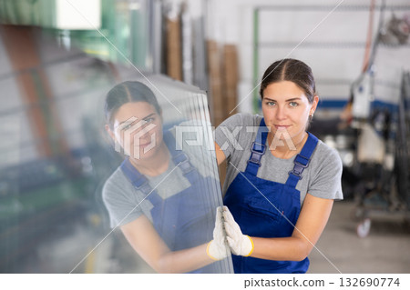 Female foreman inspecting plate glass cut to size 132690774