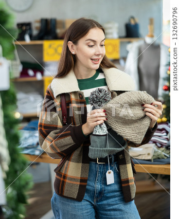 Young woman choosing hat in clothing store 132690796