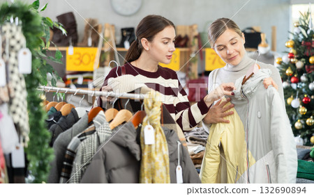 Adult and young women choosing coat or jacket in store 132690894