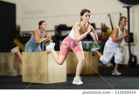 Young woman training with crossfit box Young woman training with crossfit box 132690914