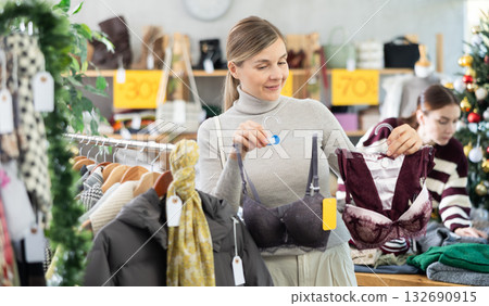 Young woman choosing bra set in Christmas boutique Young woman choosing bra set in Christmas boutique 132690915