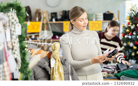 Adult woman chooses socks in clothing store Adult woman chooses socks in clothing store 132690932